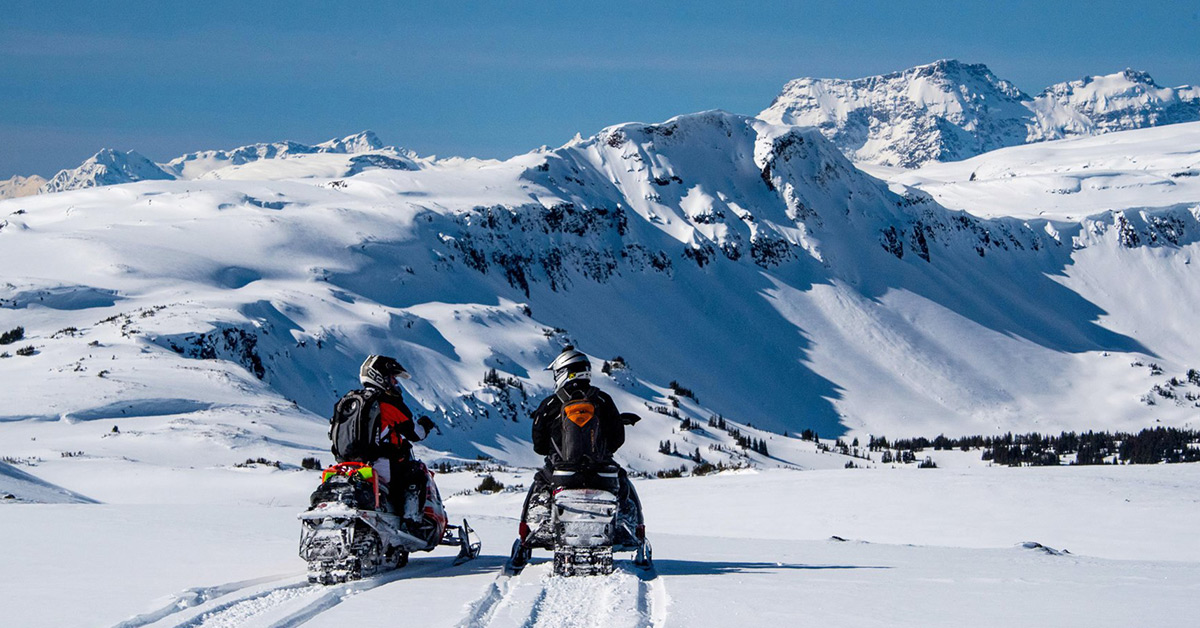 Two snowmobilers on the Rainbow Range