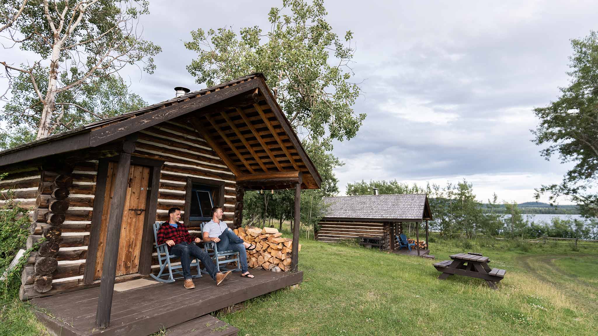Two men sitting in front of a cabin